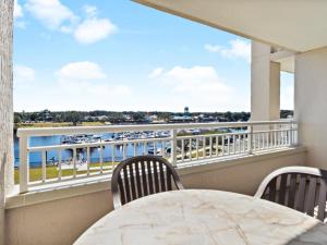balkon ze stołem i krzesłami oraz widokiem na wodę w obiekcie Yacht Club Villas #2-405 condo w mieście Myrtle Beach