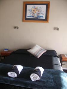 a bedroom with a bed with a pair of socks on it at Sun Valley Motel in Wellsford