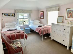 um quarto com 2 camas individuais e uma cómoda em Holbrook House em Kent