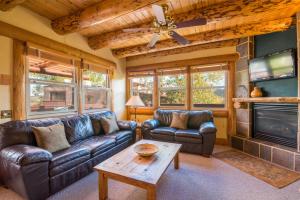 a living room with leather furniture and a flat screen tv at Chipeta Lodge in Ridgway