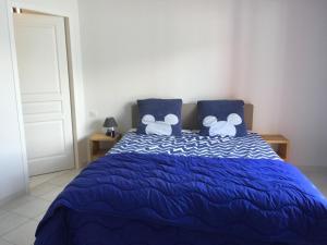 a bedroom with a blue bed with blue pillows at leparadisachorges in Chorges