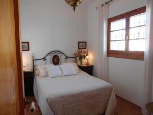 Un dormitorio con una cama con sábanas blancas y una ventana. en Penthouse Sleeps 4 with Private Garden, en Chipiona