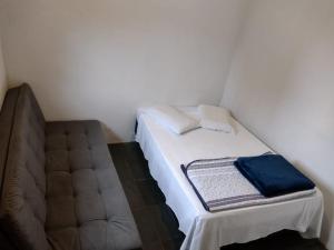 a small bedroom with a bed and a couch at Casa Cogumelo Azul in São Thomé das Letras