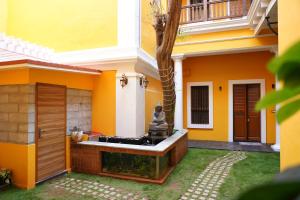 a house with a fountain in the yard at Pearl bell Villa in Puducherry
