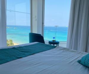 a bedroom with a bed and a view of the ocean at Silver Sands Beach Hotel in Protaras