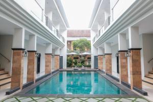 a swimming pool in the middle of a building at Guyana Hotel in Kuta