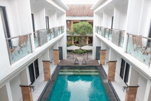 an indoor pool in the middle of a building at Guyana Hotel in Kuta