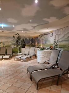 a row of chairs in a room with a mural at Hotel Matschner in Ramsau am Dachstein