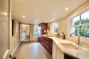 a large kitchen with a sink and a large window at Holbrook House in Kent