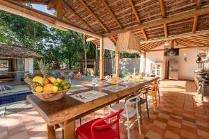 uma sala de jantar ao ar livre com uma mesa com uma taça de fruta em Casa Caminho do Mar (TRANCOSO-BA) em Trancoso