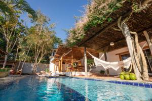uma piscina com rede ao lado de uma casa em Casa Caminho do Mar (TRANCOSO-BA) em Trancoso