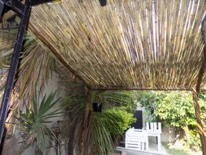 a straw pavilion with two chairs and a palm tree at Phumla@Lu's in Johannesburg