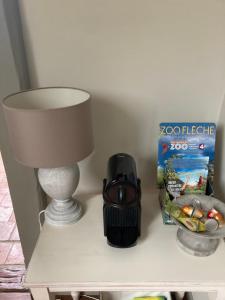 a table with a lamp and a box on it at Les Chambres du Roi in La Flèche