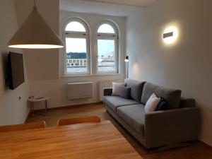 a living room with a couch and two windows at Hager Apartment 3 in Merano