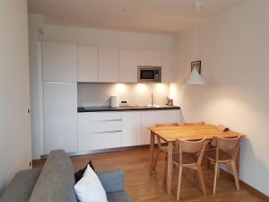 a kitchen and dining room with a table and a couch at Hager Apartment 3 in Merano