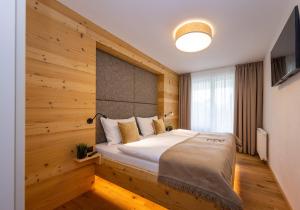 een slaapkamer met een bed met een houten muur bij FESH LIVING in Kaprun