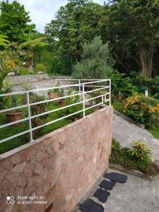 a fence on top of a stone wall at L'hibiscus By Nid'Ouest - Grand T3 - Parking privé in Le Lamentin