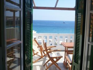 a view of the ocean from a balcony with a table and chairs at Vassiliki Studios in Andros