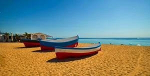Tre barche sedute su una spiaggia vicino all'oceano di Can Mir Badalona a Badalona