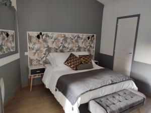 una camera con un letto con una grande testiera di Charmante maisonnette à 2 min du Centre Ville a Casteljaloux