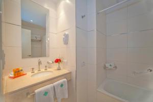 a white bathroom with a sink and a shower at Hotel Esmeralda Select in Mar del Plata