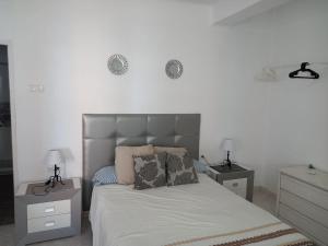 sypialnia z łóżkiem z 2 stolikami nocnymi i 2 lampami w obiekcie Centric apartment in Malaga w Maladze