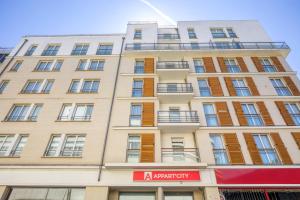 un edificio alto con una señal roja delante de él en Appart'City Confort Paris Clichy - Mairie en Clichy