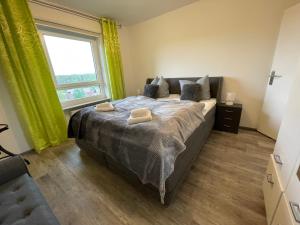 um quarto com uma cama com cortinas amarelas e uma janela em Harzer Traum - renoviert, inklusive Wäsche und WLAN em Braunlage