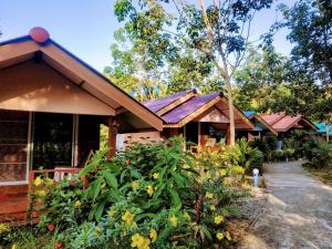 a group of houses with flowers in front of them at Phusam Big Resort in Ko Mook