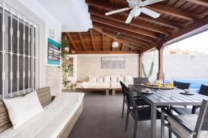 a patio with a table and chairs and a couch at LUXURY VILLA WITH PRIVATE POOL WITH AIRCON,Playa del Duque in Adeje