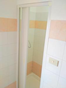 een douche in de badkamer met een witte douche achter de deur bij La dolce vita, relax & kite Falerna in Falerna