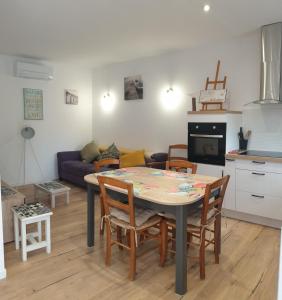 cocina y sala de estar con mesa y sillas en L'Annexe, en Sigean