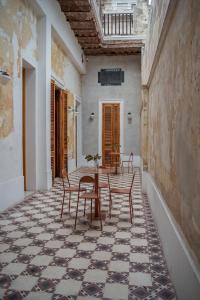 a room with a table and chairs on a tiled floor at Hotel Casa Allegra Art Suites in Rosario