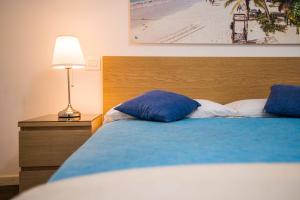 una camera da letto con un letto con cuscini blu e una lampada di Bed&Breakfast Salerno a Salerno