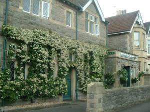 a stone building with flowers on the side of it at Lewinsdale Lodge in Weston-super-Mare