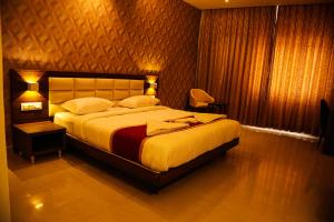 a bedroom with a large bed in a room at Royal Indraprastha The Hotel in Bengaluru