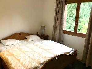 un letto in una camera da letto con finestra di Mountain River Luxury Apartment a Val-d'Illiez