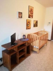 a room with a desk with a laptop and a crib at Casa Molinara in Negrar
