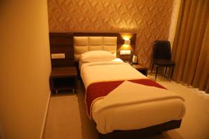 a hotel room with a bed and a table and a chair at Royal Indraprastha The Hotel in Bengaluru