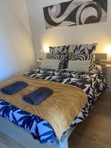 a bedroom with a bed with blue pillows on it at L'Amarelo in Montauban