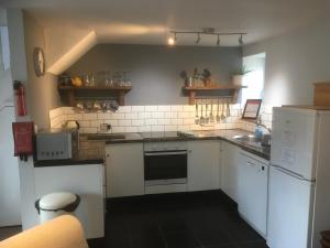 a kitchen with white appliances and a black floor at Maesnewydd Cottage in Welshpool