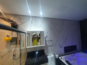 a person taking a picture in a bathroom mirror at Residencial Goulart in Capitólio +6 photos
