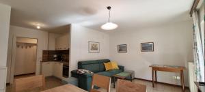 een woonkamer met een groene bank en een tafel bij Cesa Fortunato in Canazei