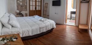 1 dormitorio con 1 cama y suelo de madera en Hotel Casa Allegra Art Suites en Rosario