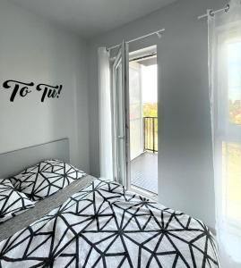 um quarto com uma cama em preto e branco e uma janela em Ach, To Tu- Apartament Łańcut em Lańcut