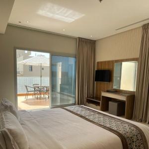a bedroom with a bed and a view of a patio at Sarwat Park Hotel Jeddah in Jeddah