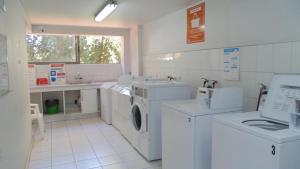 lavadero con lavadoras y fregadero en ACOGEDOR DEPARTAMENTO EN APOQUINDO, en Santiago