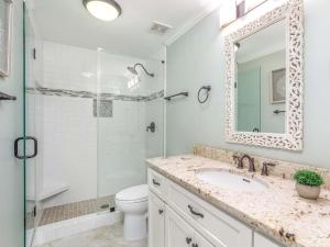 een witte badkamer met een wastafel en een douche bij A Salty Senorita in Tybee Island