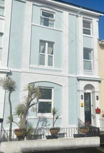 a blue and white house with plants in front of it at Babbacombe Palms in Torquay