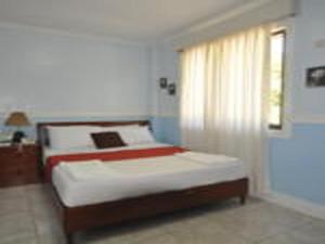 um quarto com uma cama grande e uma janela em The Gabriella Bed and Breakfast em Tagbilaran